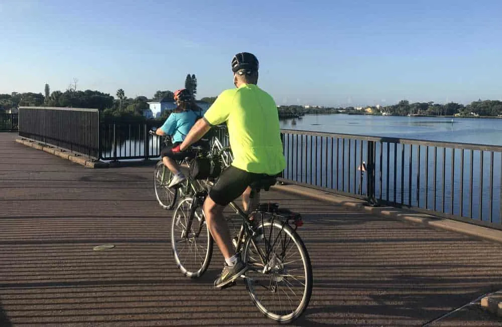 Bicyclists on bridge over water.