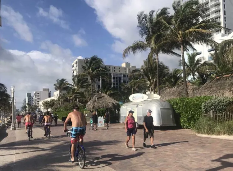 Bicyclists along the Hollywood Beach Broadwalk pass the Jimmy Buffett Margaritaville Resort, with its vintage RV, which sells snacks, beverages and sandwiches. (Photo: Bonnie Gross)
